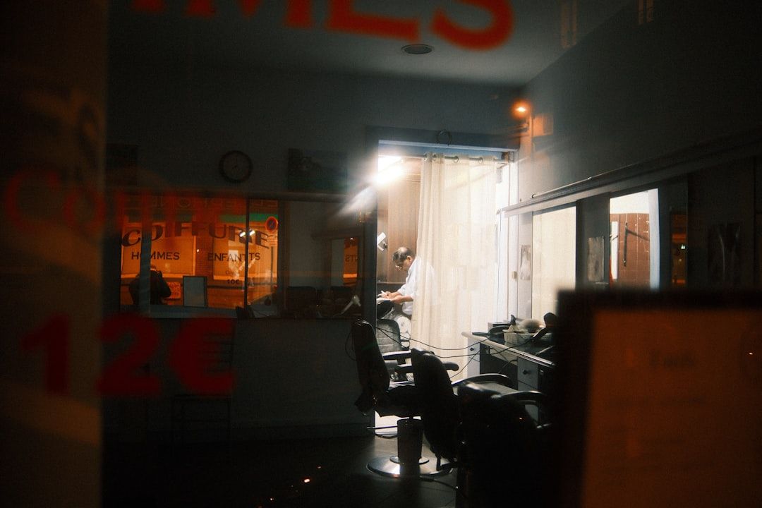 Vista des del carrer d'una barberia il·luminada de nit